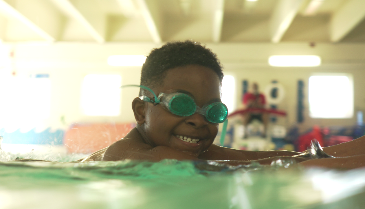Smiling young boy in an indoor swimming pool